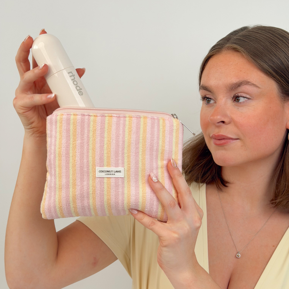 Girl holding mini towel everything pouch in pastel stripes