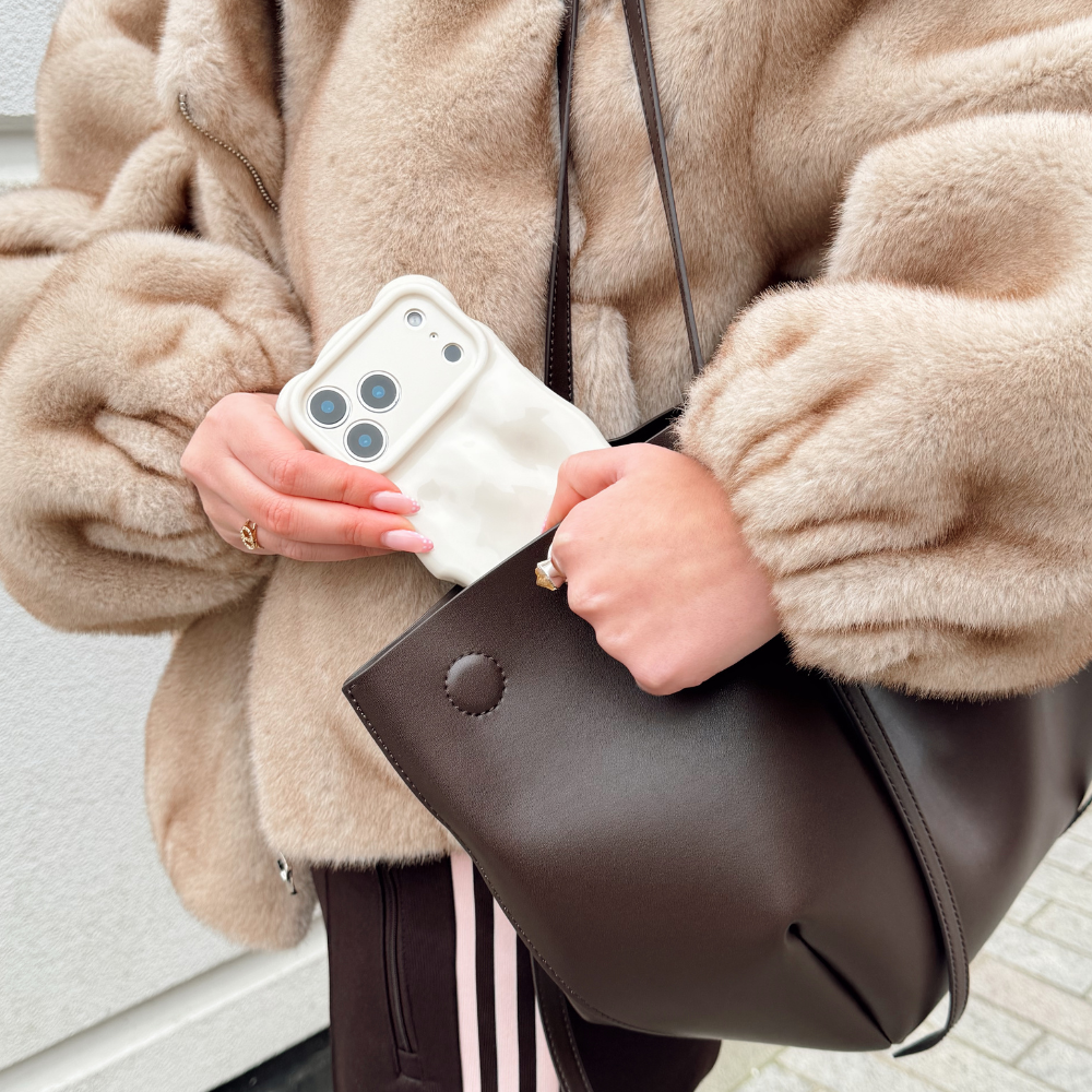 Girl in fur coat taking 3D Bubble Cloud Dancer Phone Case out of her brown bag