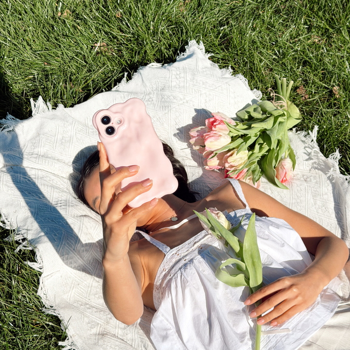 Girl at a picnic with flowers close up image taking a selfie of the 3D Bubble Phone Case in Powder Pink