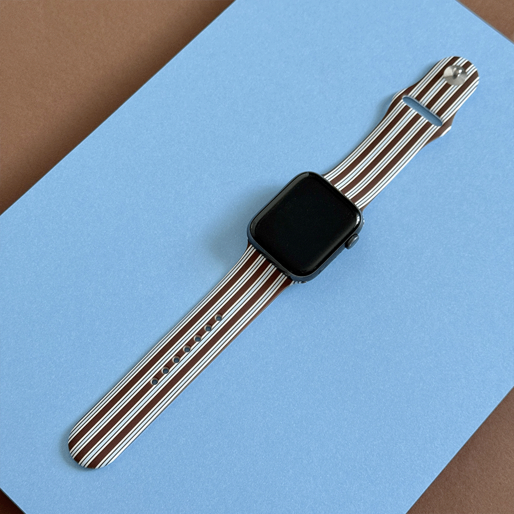 Apple Watch Strap with brown and white vertical stripes on a blue background.