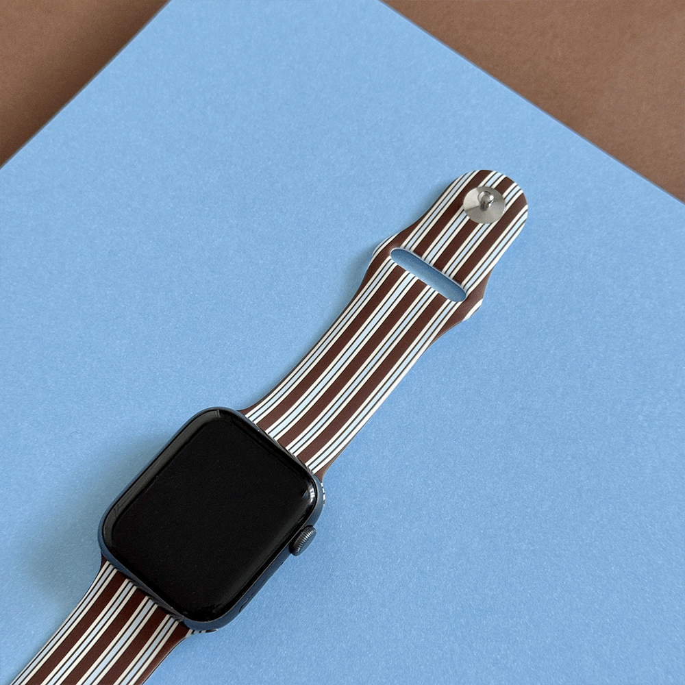 Apple Watch Strap with brown and white vertical stripes on a blue background.
