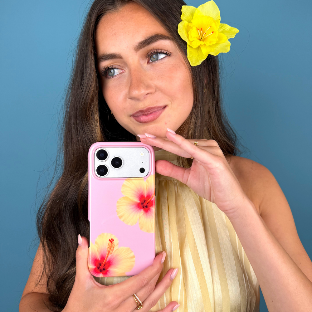 Woman holding a phone with a floral case against a blue background