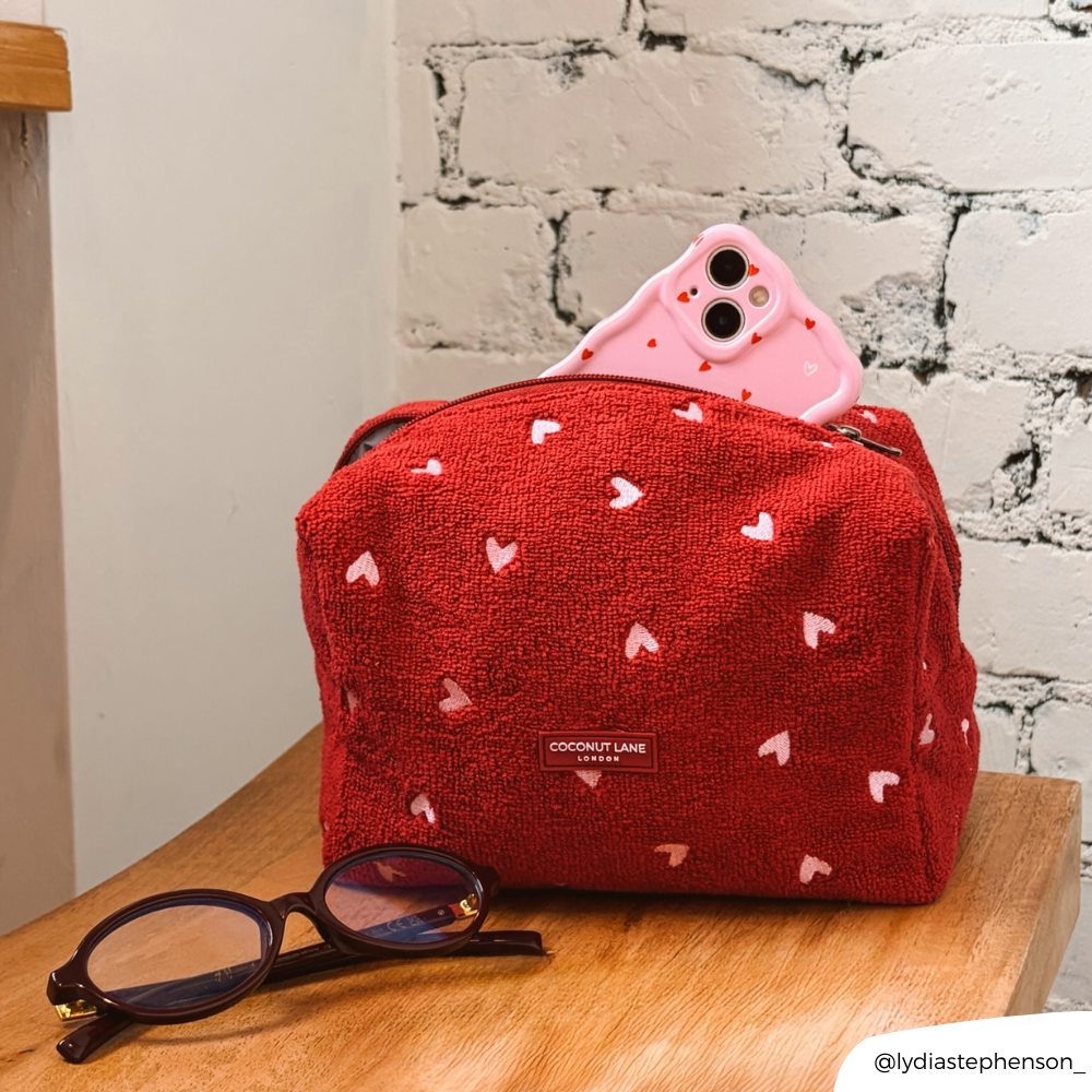 Mulberry Hearts Towel Makeup Bag on chair with Cute Hearts Phone Case inside of it next to a pair of glasses