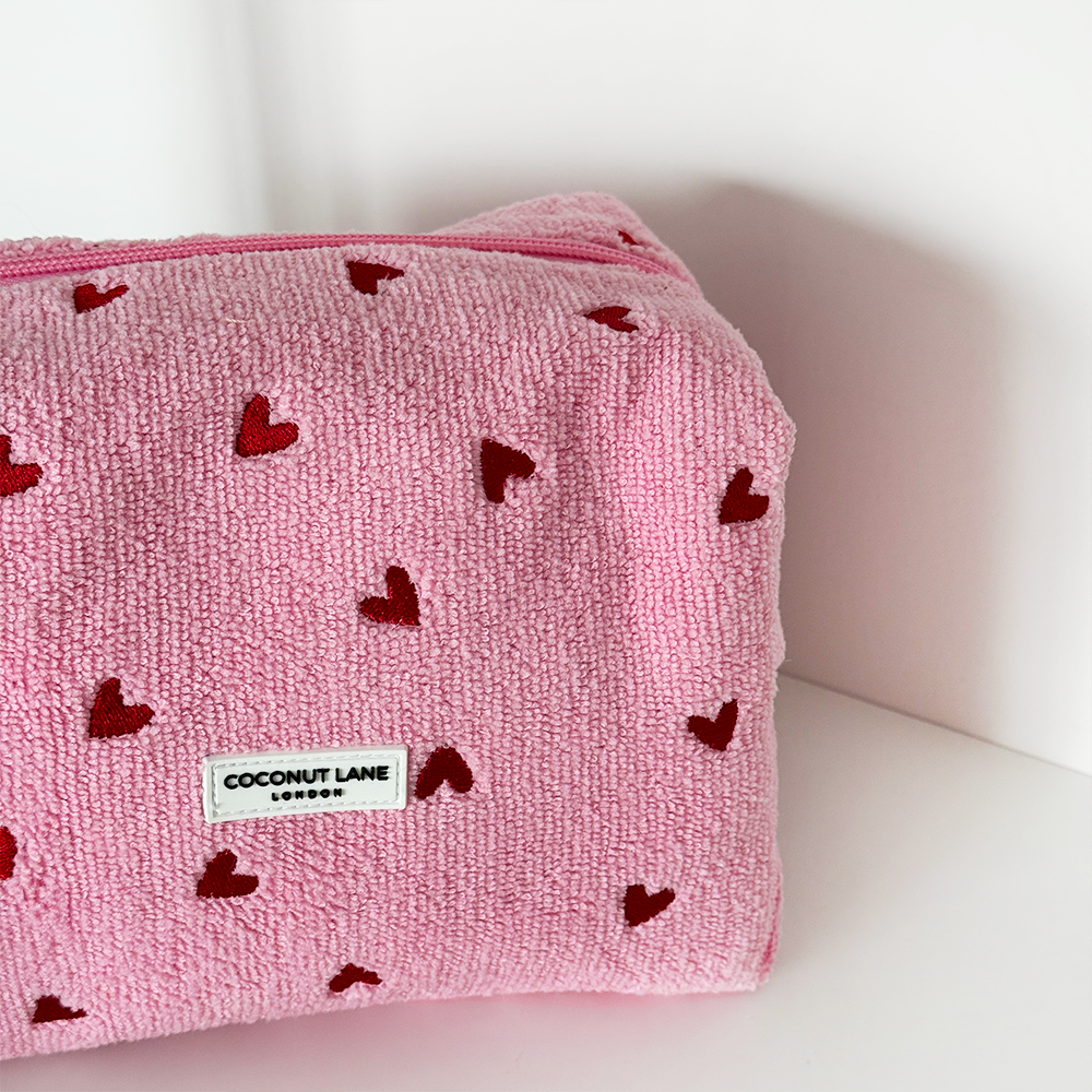 Pink pouch with red heart patterns and a Coconut Lane label on a white background