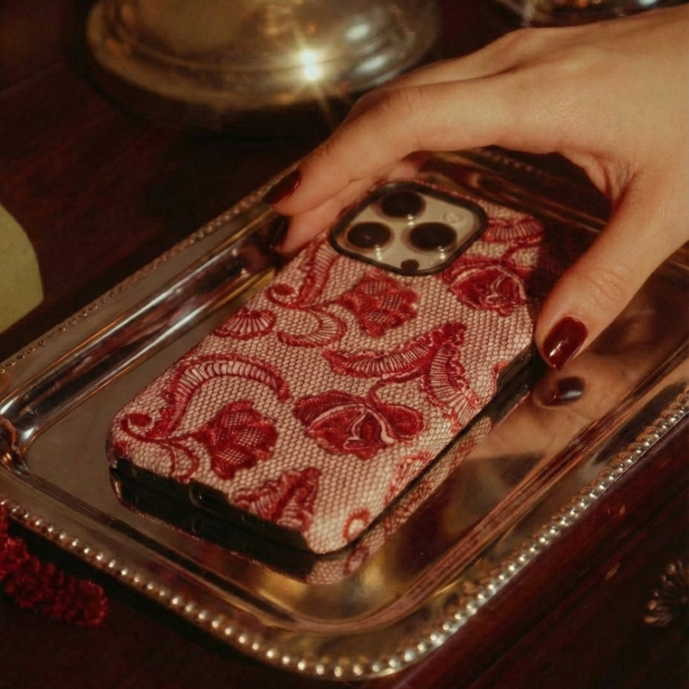 Red Lace Phone Case laying on a silver platter being picked up by a hand with red nail varnish on nails