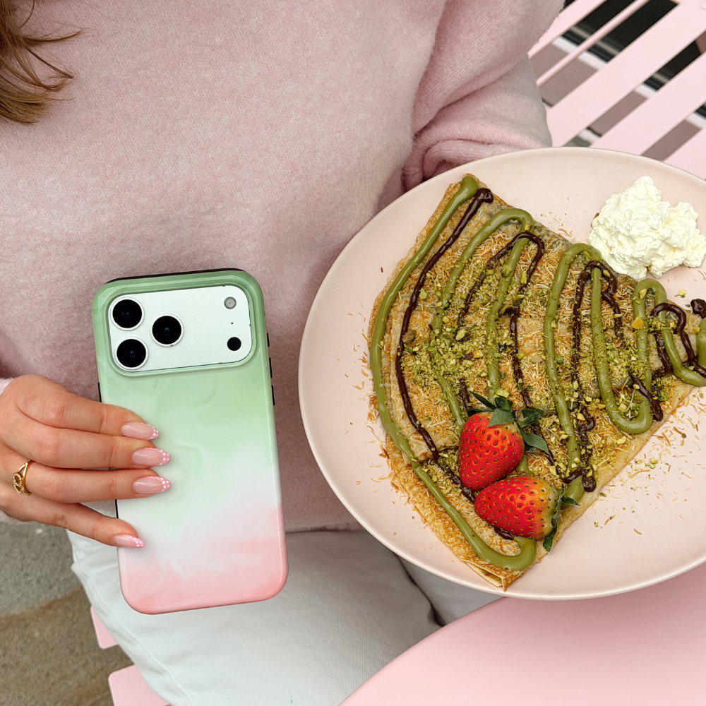 Girl at cafe holding a plate of pancakes and Tough Strawberry Matcha Phone Case