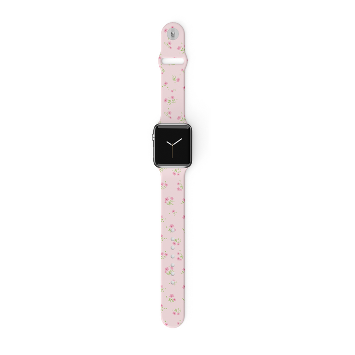 A smartwatch featuring a square black screen paired with the Coconut Lane Ditsy Floral Pink Apple Watch Strap. This silicone band is adorned with small pink flowers and green leaves, and is compatible with various Apple Watch models. The watch is displayed on a white background.