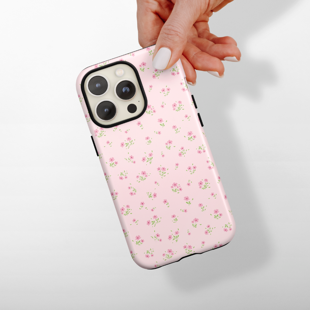 Hand holding a pink floral Coconut Lane Tough Phone Case on a smartphone, set against a white background.