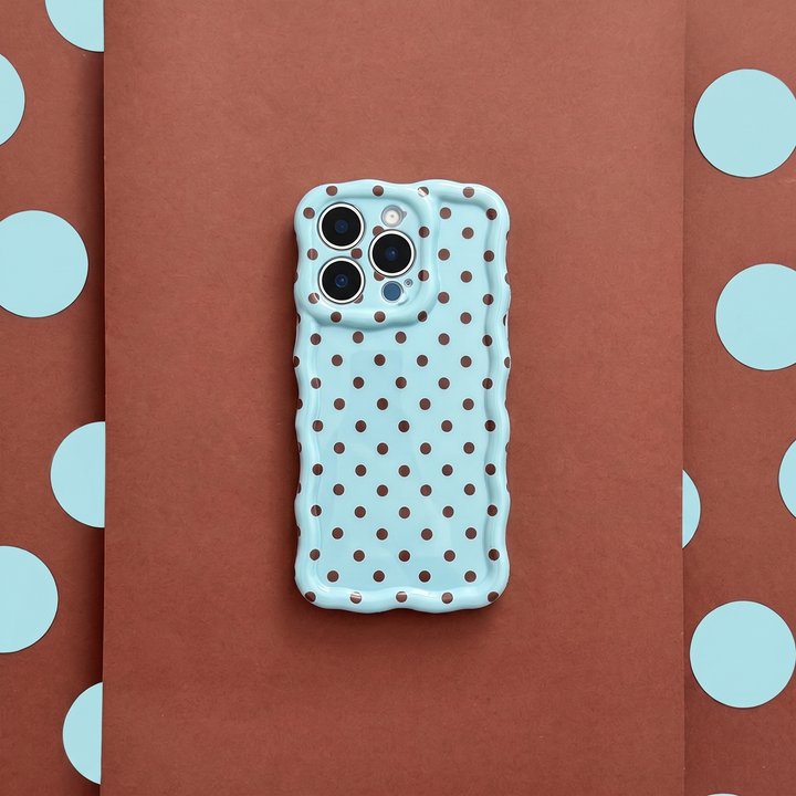 Blue polka dot phone case on a brown background with blue polka dots