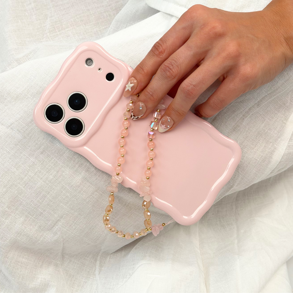 Pink and gold phone strap attached to phone case
