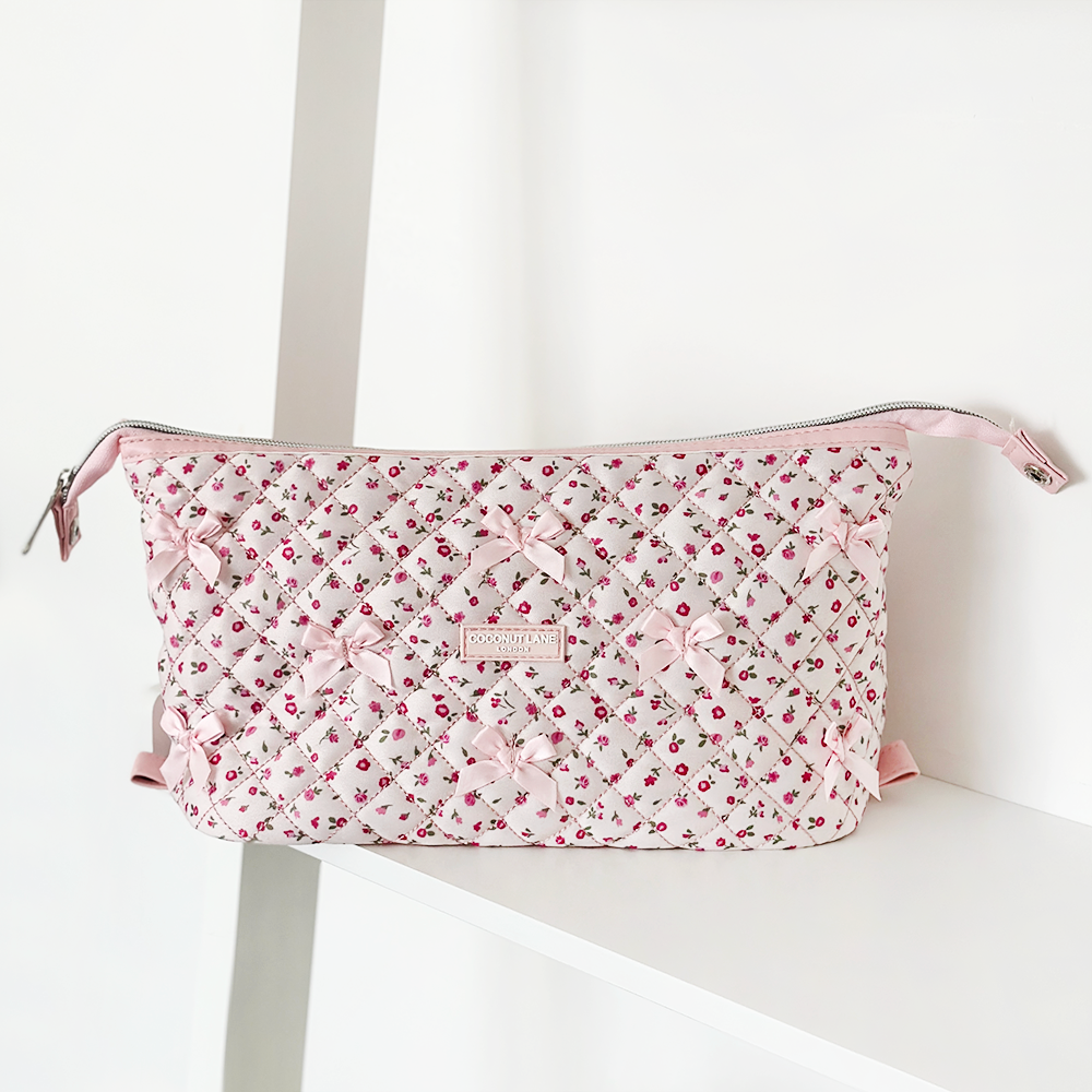 Quilted pink makeup bag with watercolor floral pattern and expandable design from Coconut Lane.